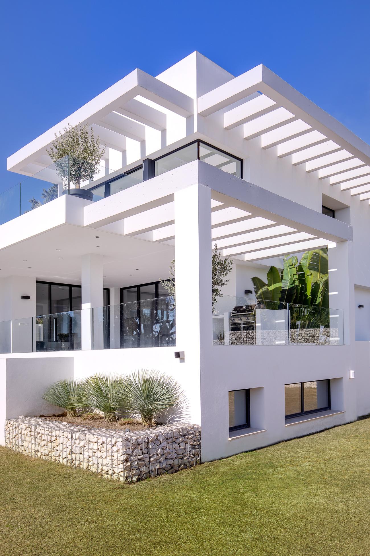 Corner of Casa Amigos with white pergolas on both floors