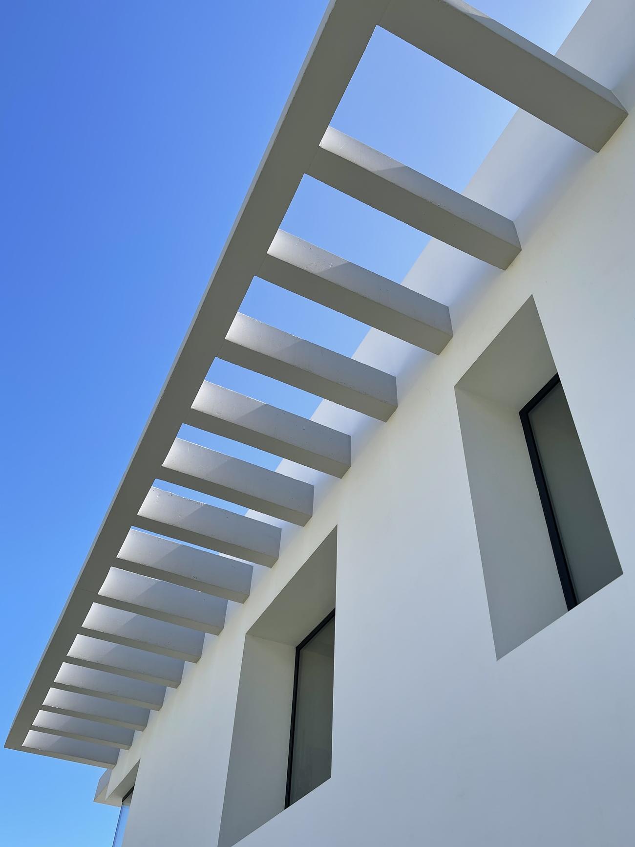 Detalle de pérgola blanca contra el cielo